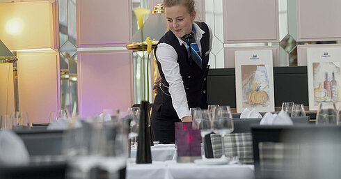 Cameriera apparecchia con stile il tavolo al ristorante del Maritim Hotel Monaco