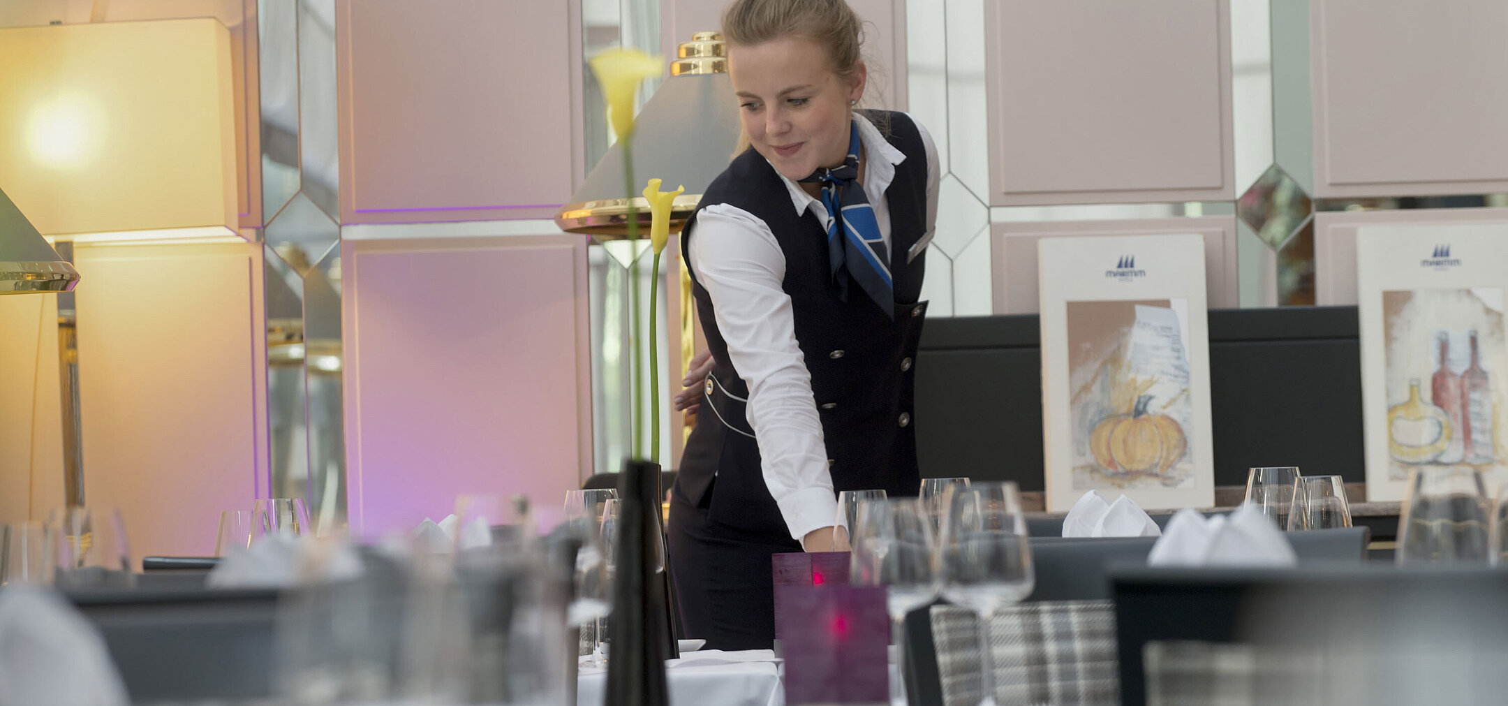 Maritim Conference Service Staff member elegantly sets the table in the restaurant at the Maritim Hotel Munich