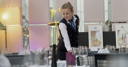 Employée prépare avec soin la table au restaurant de l’hôtel Maritim Munich