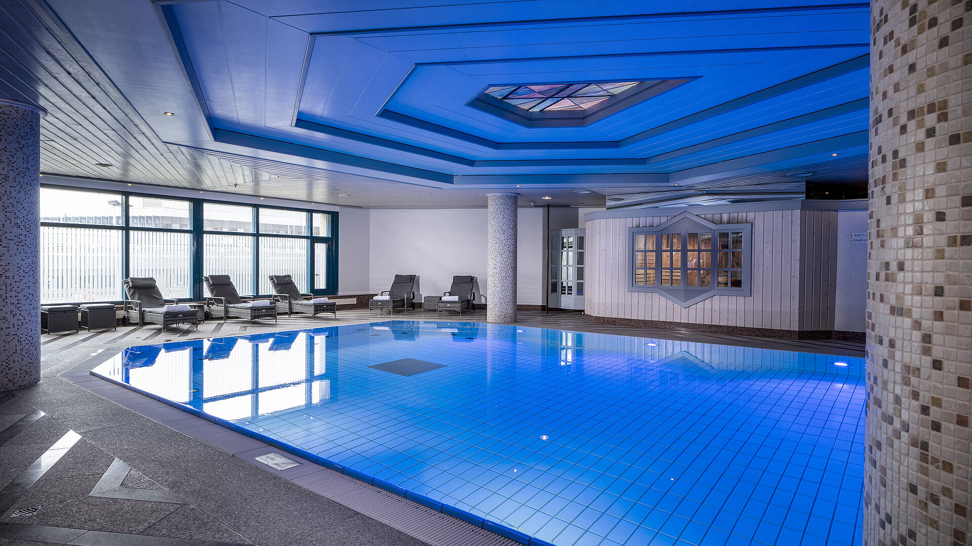 Pool Indoor pool at Maritim Hotel Hannover with loungers and modern lighting.