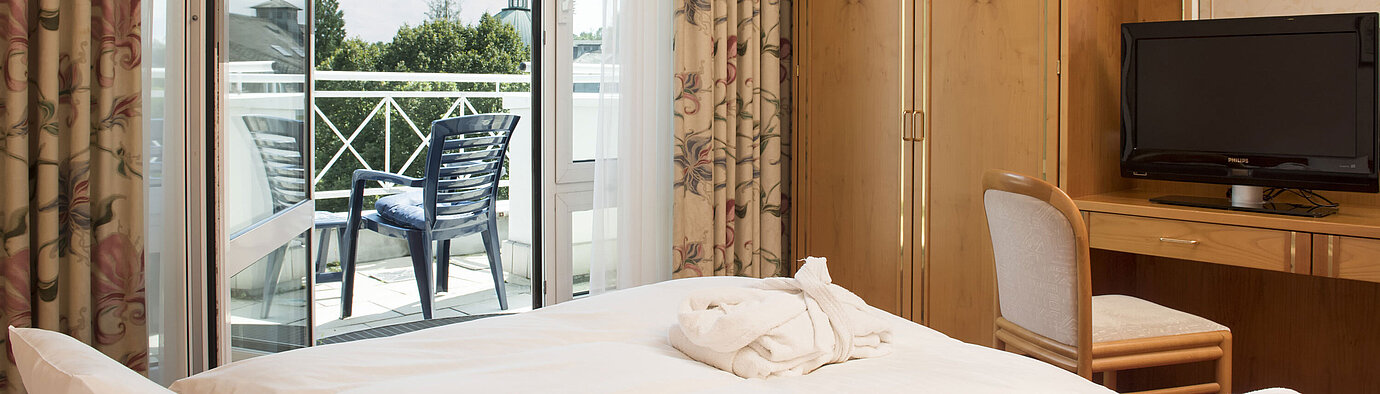 Chambre double lumineuse avec balcon, TV et armoire au Maritim Hotel Bad Wildungen