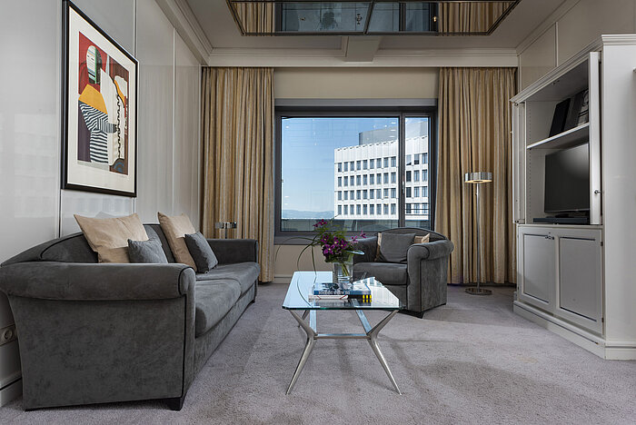 Ampia Executive Suite al Maritim Hotel Frankfurt con arredi eleganti, area salotto accogliente e finestra panoramica.