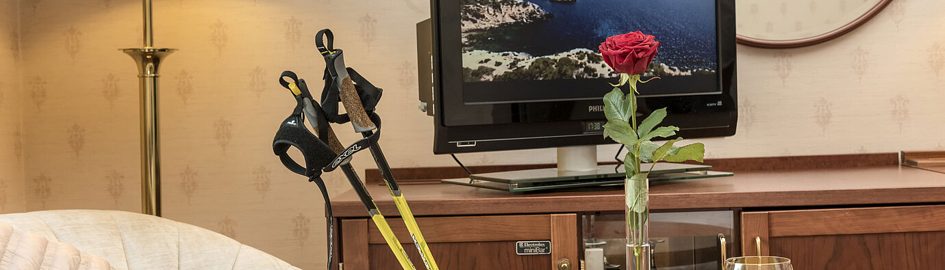 Bright lounge with Nordic walking poles, rose, TV and drink at Maritim Hotel Bad Wildungen