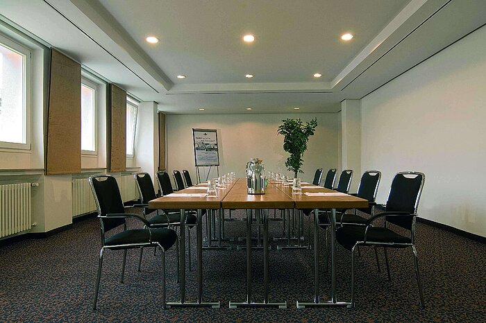 Sala de reuniones luminosa en el Maritim Hotel Fulda con equipamiento moderno y mesa de conferencia.
