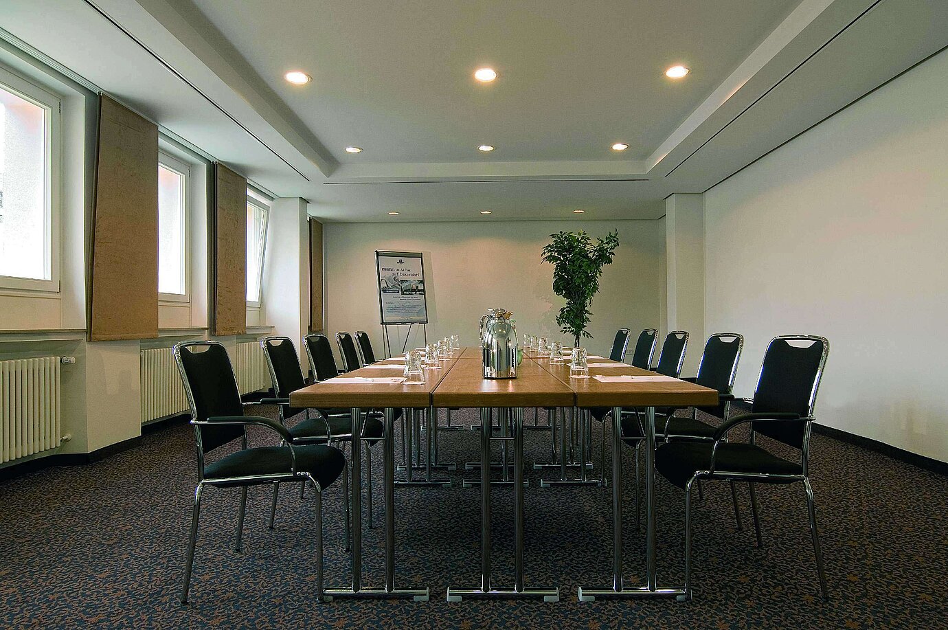 Sala de reuniones luminosa en el Maritim Hotel Fulda con equipamiento moderno y mesa de conferencia.