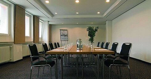 Sala de reuniones luminosa en el Maritim Hotel Fulda con equipamiento moderno y mesa de conferencia.