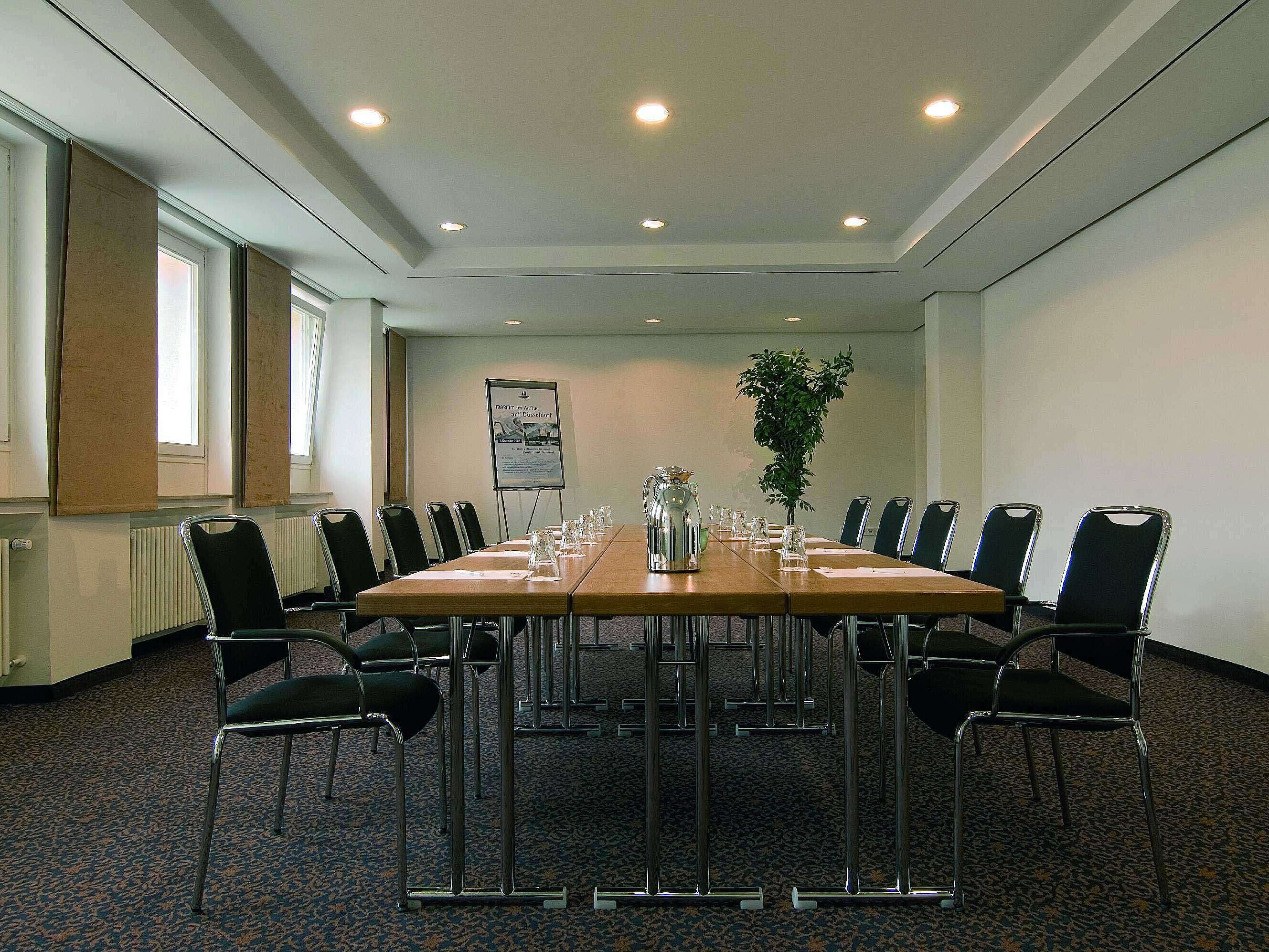 Sala de reuniones luminosa en el Maritim Hotel Fulda con equipamiento moderno y mesa de conferencia.