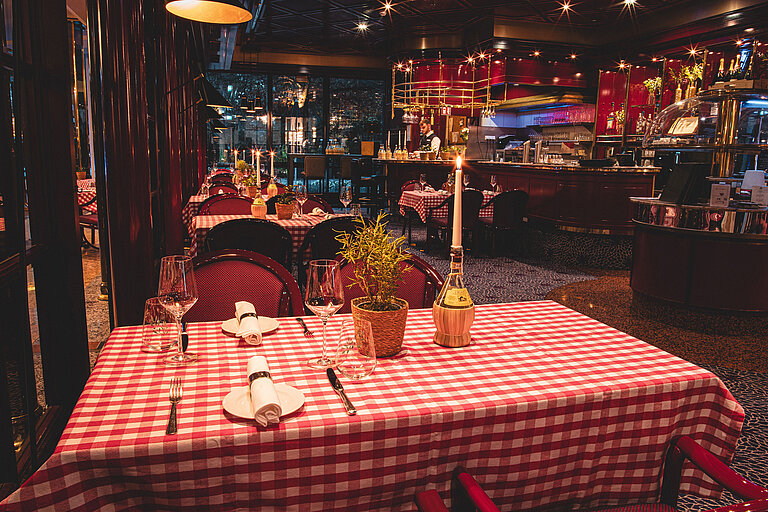Restaurant Brasserie Table de restaurant cosy avec bougie et motif à carreaux rouges le soir