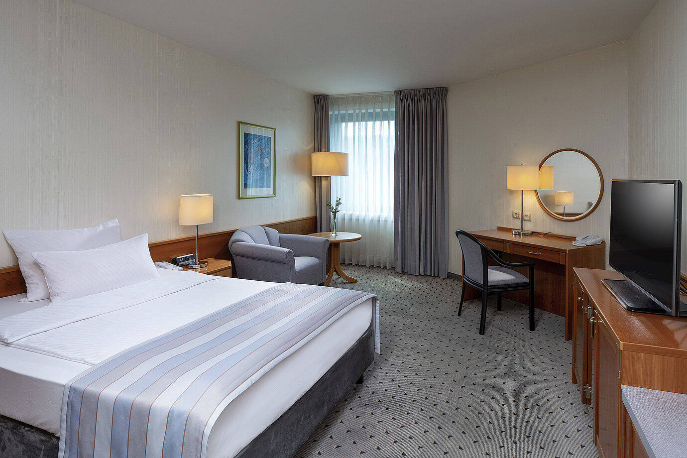 Camera Classic accogliente con letto grande, scrivania, TV e arredo elegante al Maritim Hotel Hannover.
