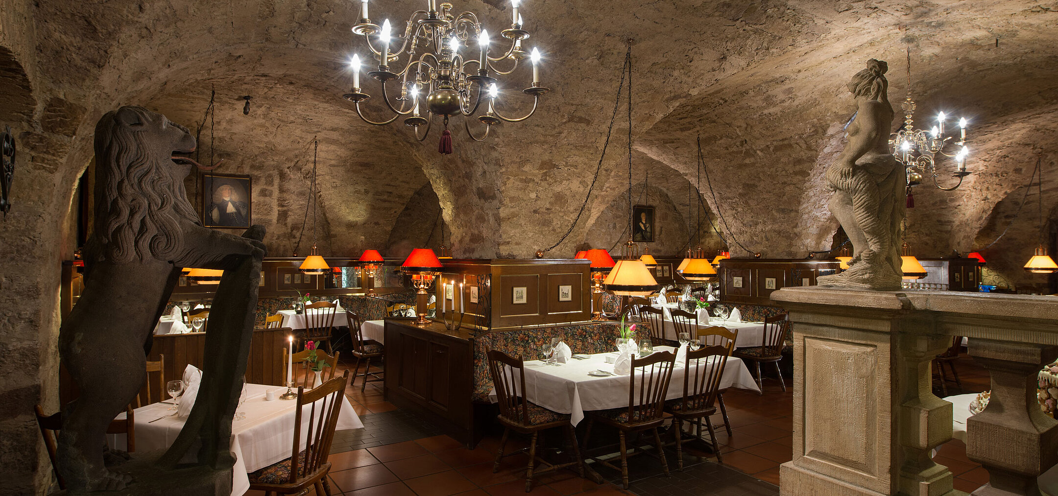 Restaurante histórico en Maritim Hotel Fulda con techo abovedado, luz de velas y ambiente rústico.
