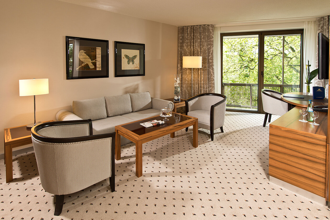 Área de estar acogedora de la suite en el Hotel Maritim Bad Homburg con zona de asientos elegante y balcón.
