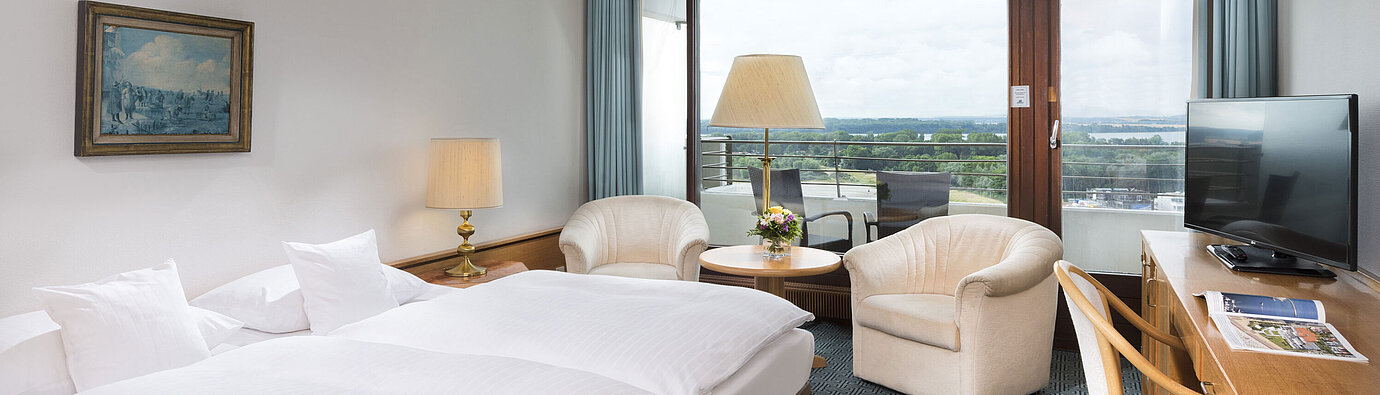 ComfortPlus room  Double room with seating area, desk and balcony overlooking green landscape in Travemünde