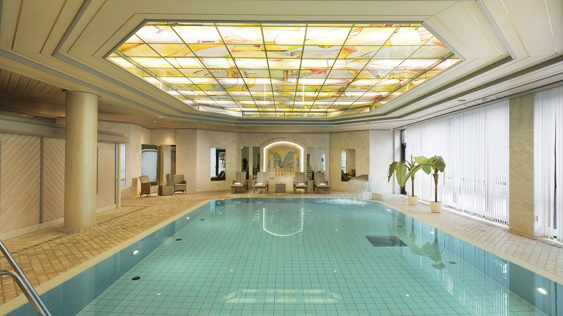 Piscina Piscina interior con tragaluz y tumbonas en el Maritim Hotel Ulm