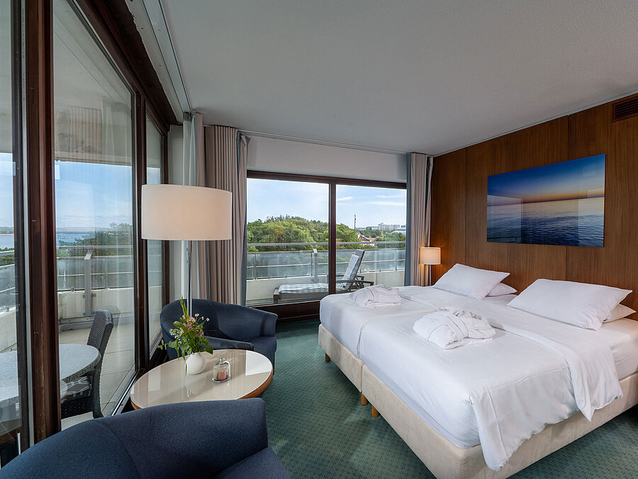 SuperiorPlus Room facing the sea with double bed, seating area and views of the Baltic Sea and greenery