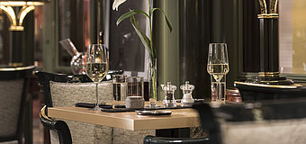 Mesa elegante con flor y copas de vino en el restaurante La Marée, Maritim Hotel Bonn, ideal para una cena elegante.