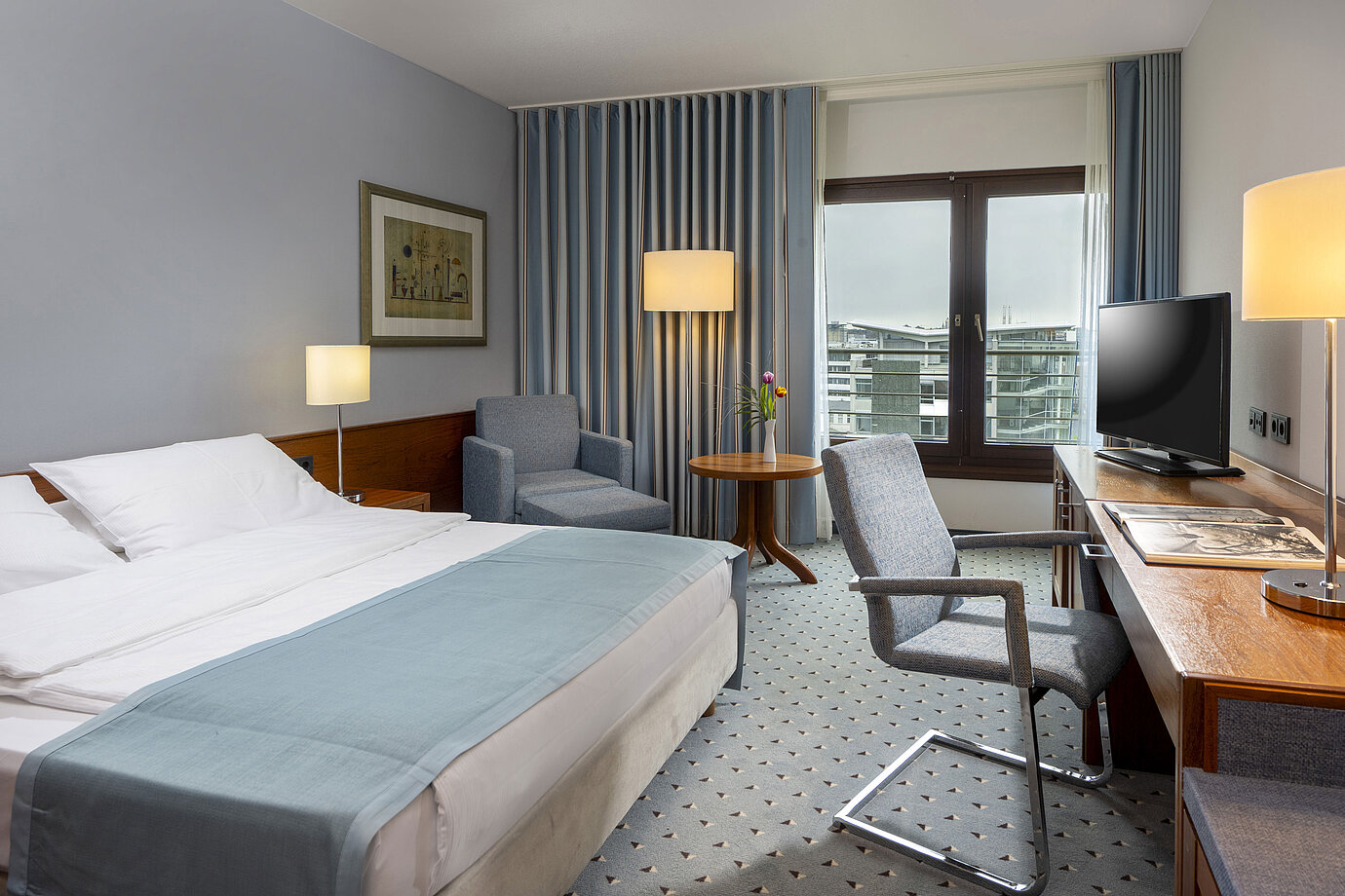 Comfort double room at Maritim Hotel Darmstadt with cozy seating area, modern desk, and city view.