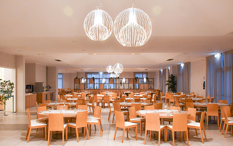Ampia sala da pranzo al Maritim Resort Calabria con luci eleganti e tanti posti a sedere
