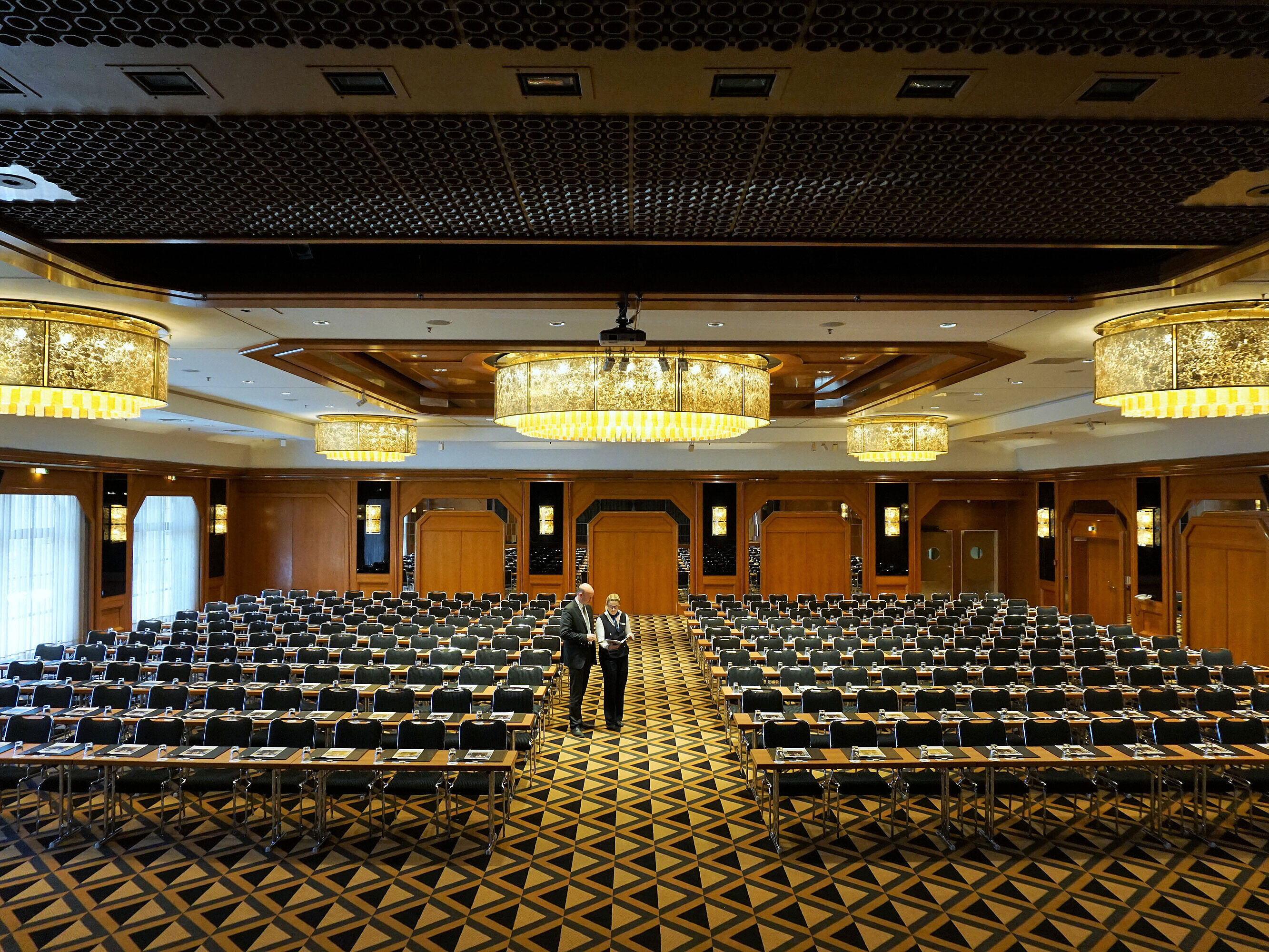 Elegante sala de conferencias en Maritim Hotel Königswinter con asientos modernos y grandes lámparas.