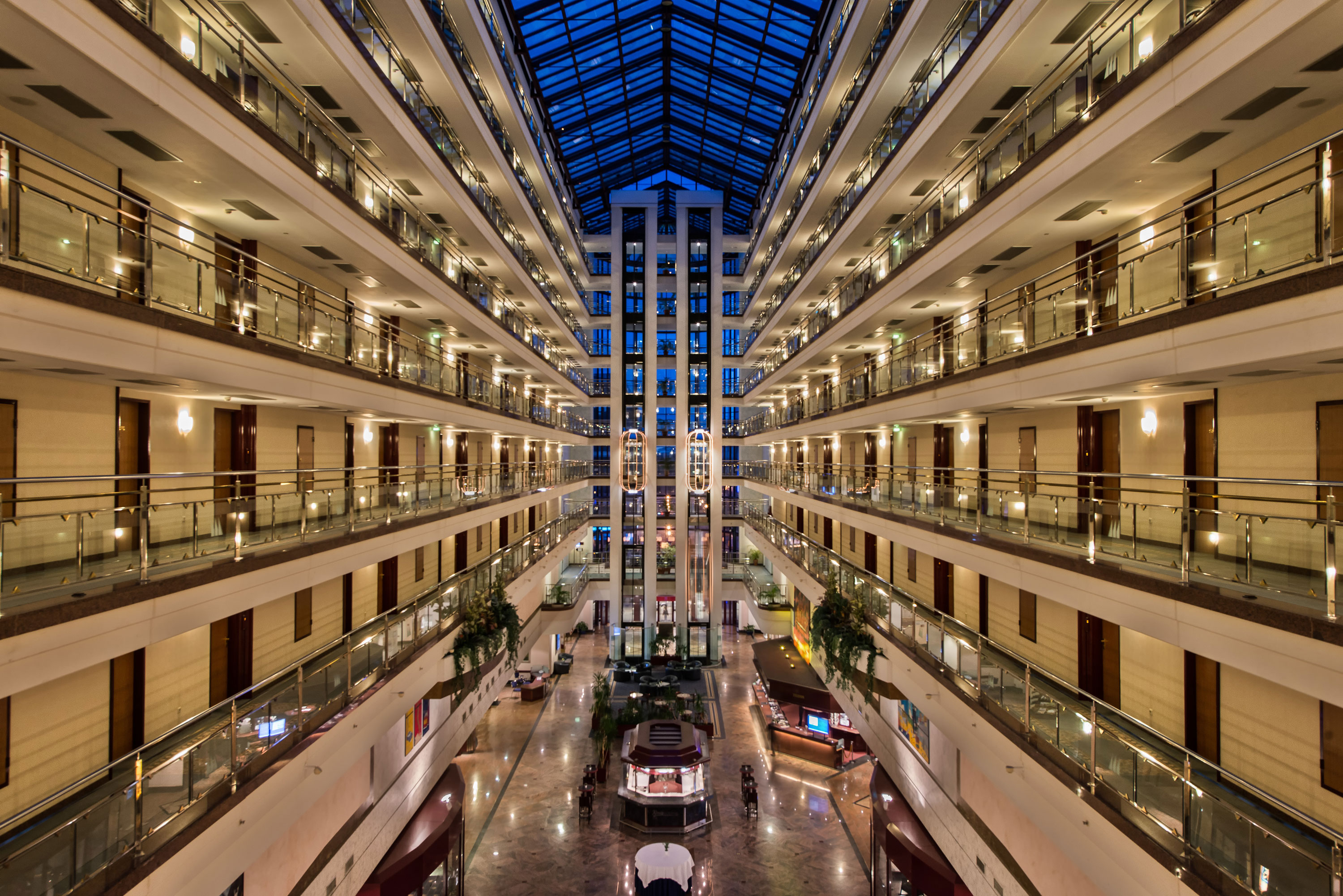The spacious, bright lobby of Maritim Hotel with illuminated floors and modern architecture at night.