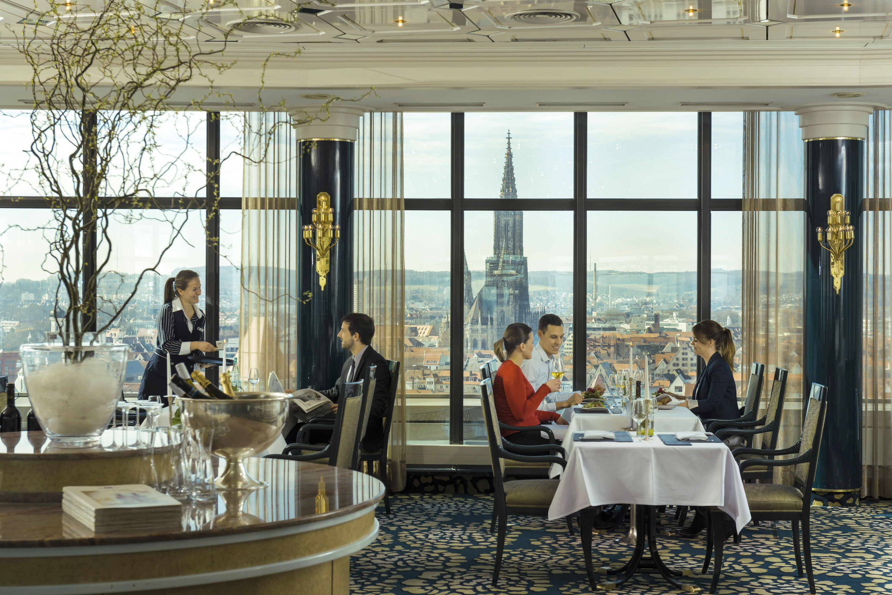 Guests enjoying a meal with a view of Ulm Minster at the panorama restaurant of Maritim Hotel Ulm