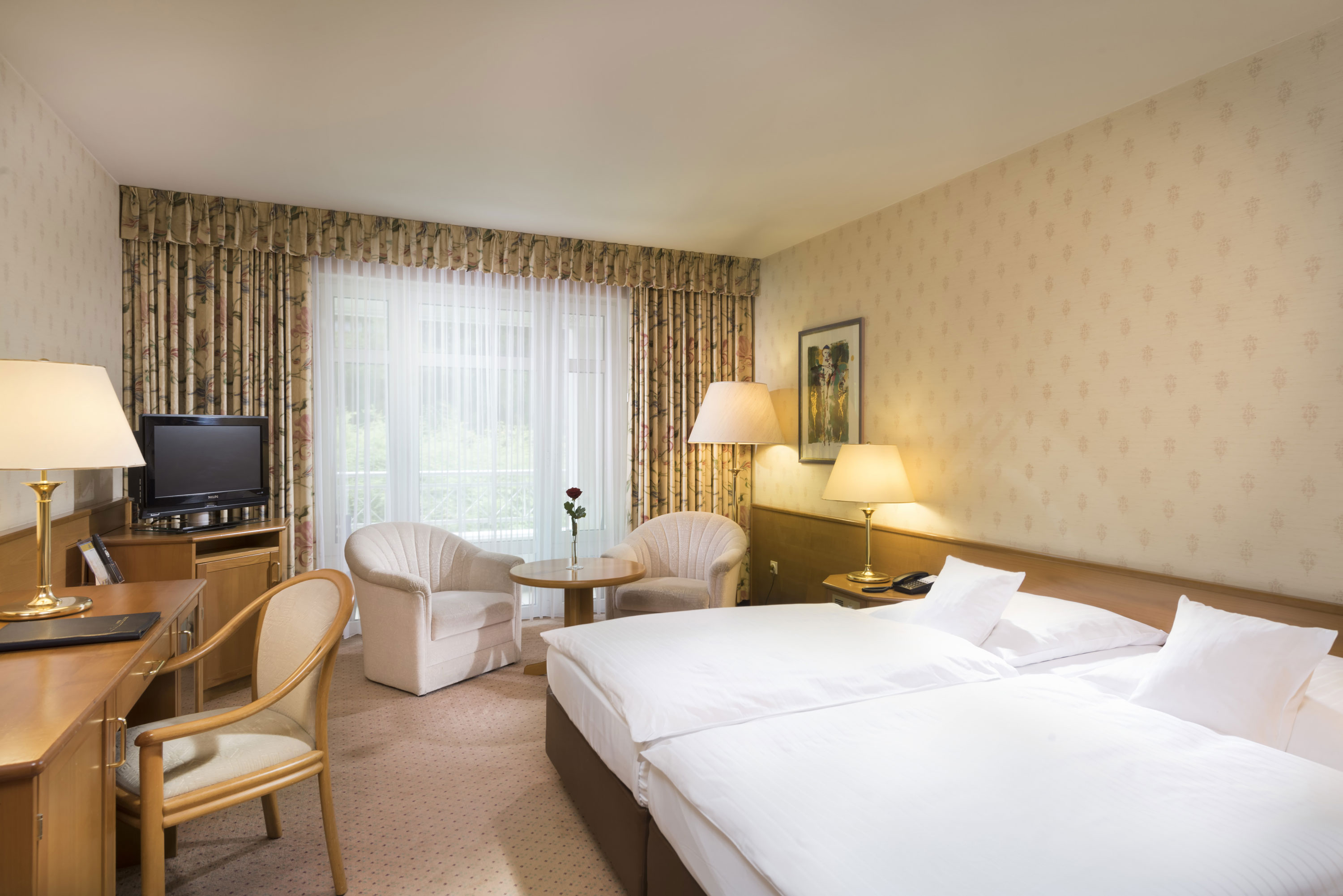 Bright double room with seating area and desk at Maritim Hotel Bad Wildungen