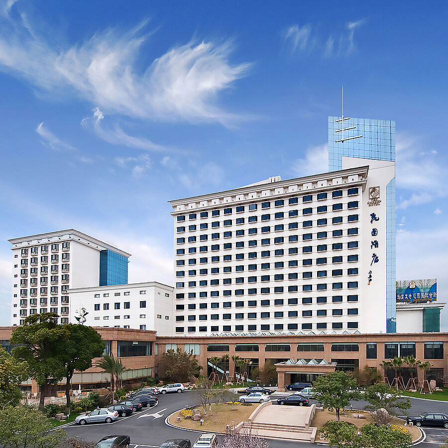 Exterior view Exterior view of the hotel with tall façade, modern extension and surrounding greenery creating a welcoming impression