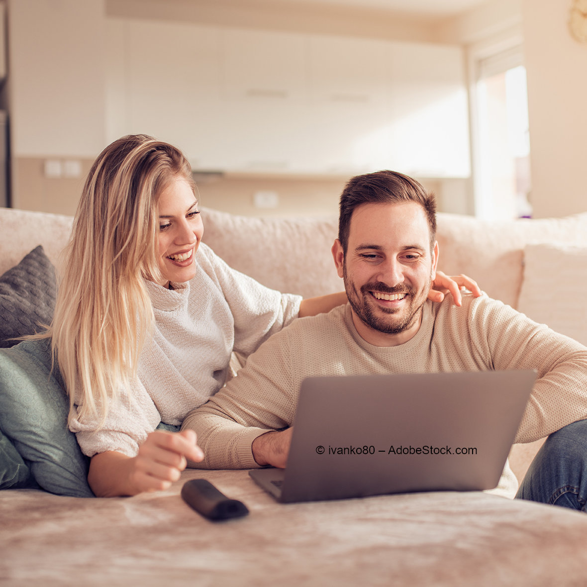 © ivanko80 - AdobeStock.com Couple relaxing on sofa while watching laptop together